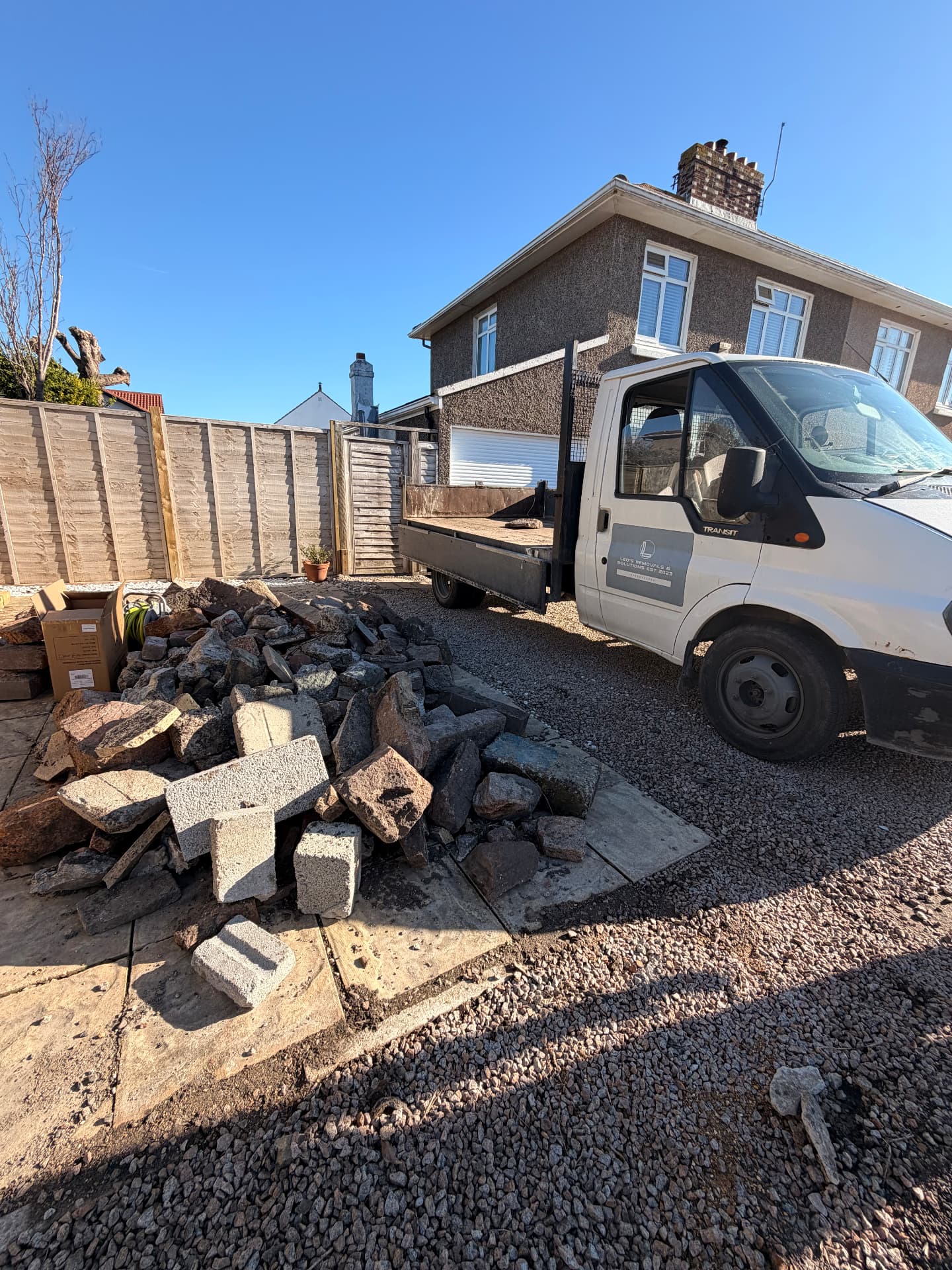 Leo's Removals van beside a cleared pile of rubble
